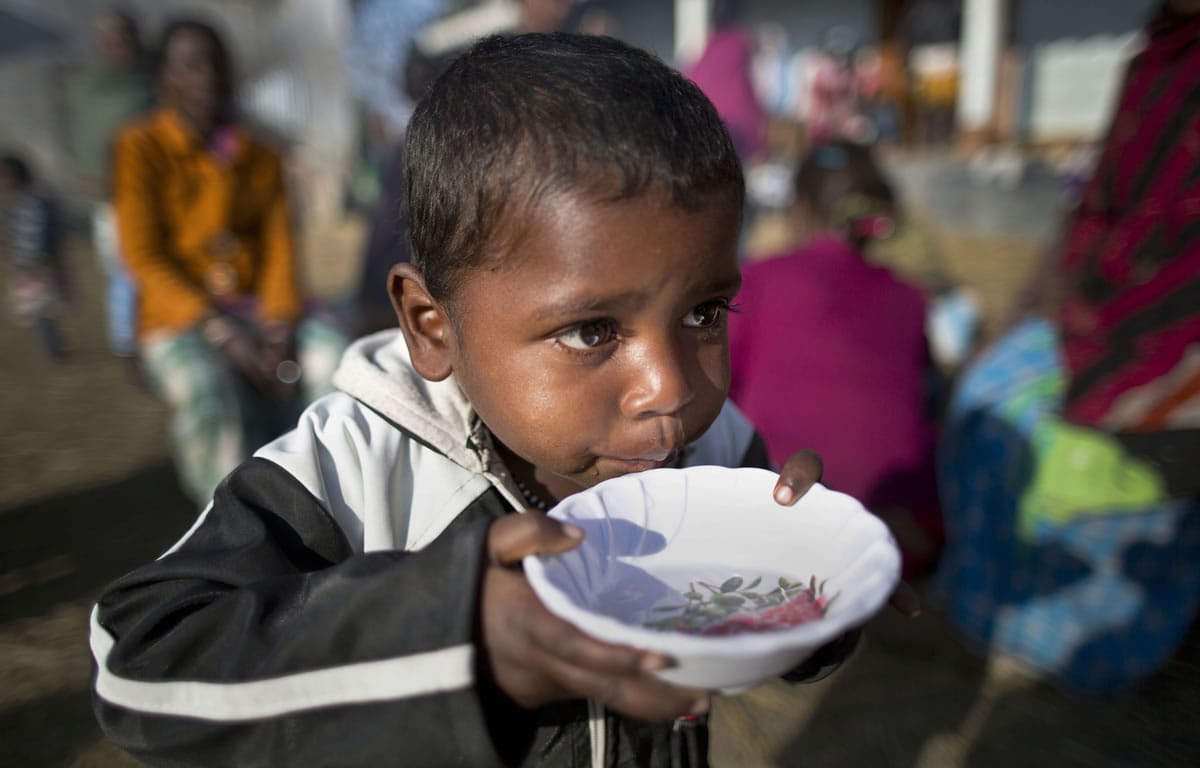 An Indian tribal child drinks water in a bowl at a relief camp at Tinsuti village in Sonitpur district of Indian eastern state of Assam, India, on Thursday.