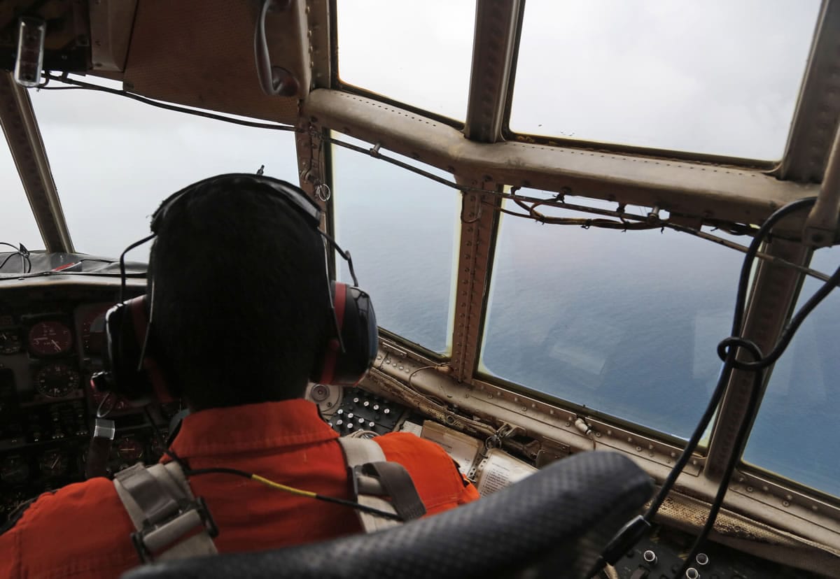 A crew of an Indonesian Air Force C-130 airplane of the 31st Air Squadron scans the horizon during a search operation Monday for the missing AirAsia flight 8501 jetliner over the waters of Karimata Strait in Indonesia. Search planes and ships from several countries on Monday were scouring Indonesian waters over which an AirAsia jet disappeared, more than a day into the region's latest aviation mystery.