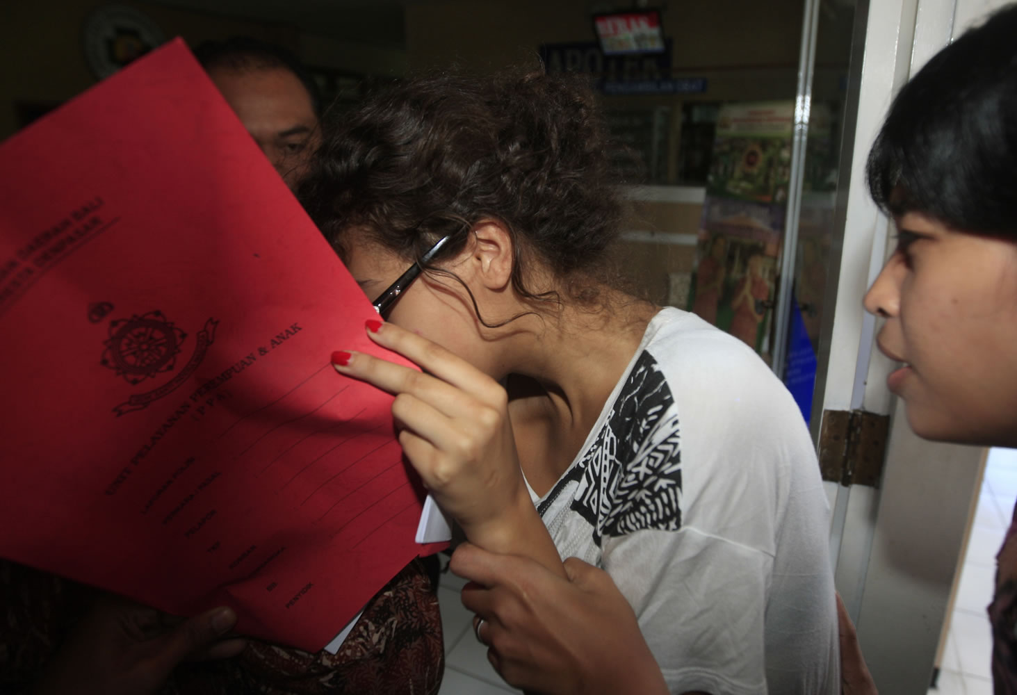 Heather Mack, covering her face, is led to a hospital for a medical check by Indonesian police officers in relation to the death of her mother Sheila von Wiese-Mack in Bali, Indonesia, on Friday, Aug. 15.