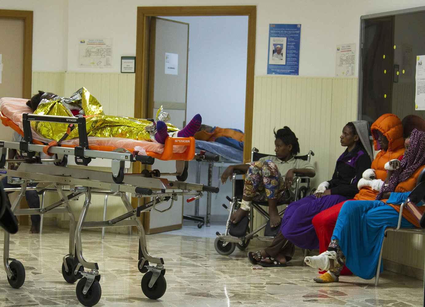 Injured women wait to be treated Friday in the hospital of Lampedusa Island, southern Italy. According to rescuers the women were injured in the explosion of a gas cylinder before leaving for Italy. An unprecedented wave of migrants has headed for the European Union's promised shores over the past week, with 10,000 people making the trip.