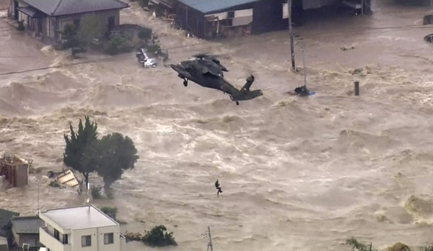 In this photo taken from video provided by Japan's Tokyo Broadcasting System television network, a man, who was stranded in the middle of raging floodwaters, is rescued by a military helicopter in Joso, Ibaraki prefecture Thursday. Raging floodwaters broke through a berm Thursday and swamped the city near Tokyo, washing away houses, forcing dozens of people to rooftops to await helicopter rescues and leaving one man clinging for his life to a utility pole.