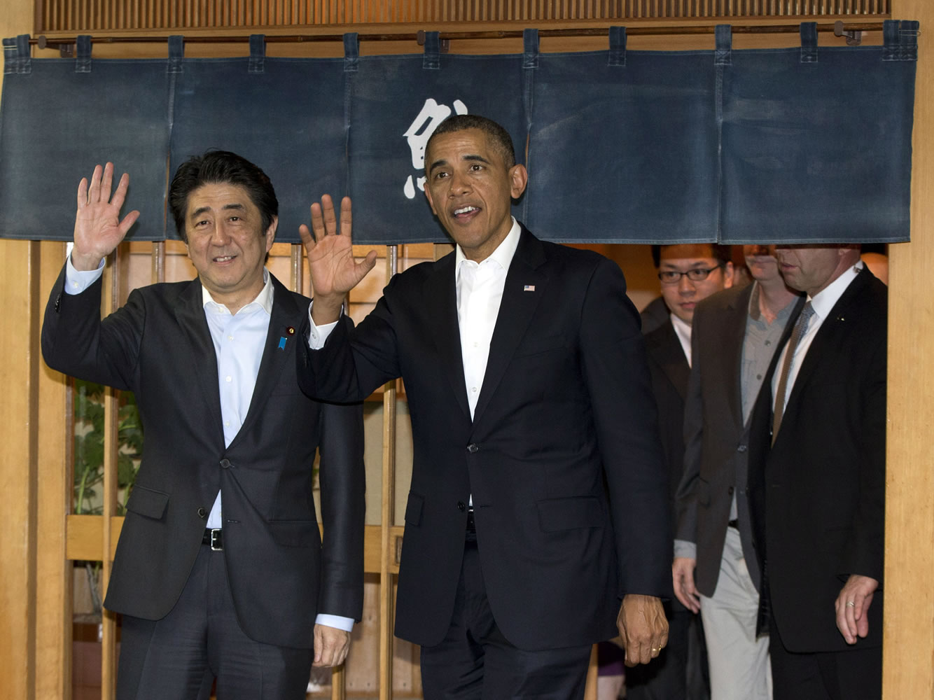President Barack Obama and Japanese Prime Minister Shinzo Abe wave to media as they depart Sukiyabashi Jiro sushi restaurant in Tokyo on Wednesday.