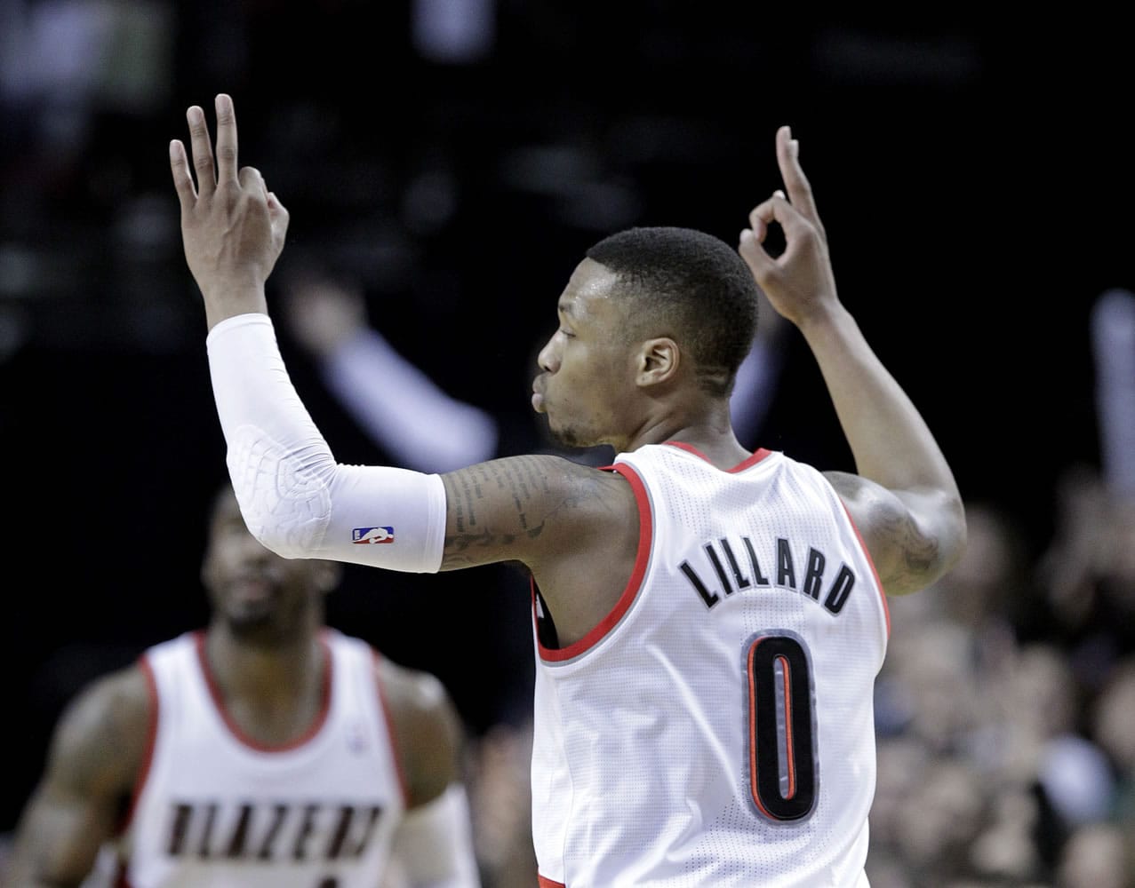 Portland Trail Blazers guard Damian Lillard signals after sinking a three  point shot during the second half of an NBA basketball game against the Utah Jazz in Portland, Ore., Friday, Feb. 21, 2014.  Lillard led Portland in scoring with 28 points as they won 102-94.