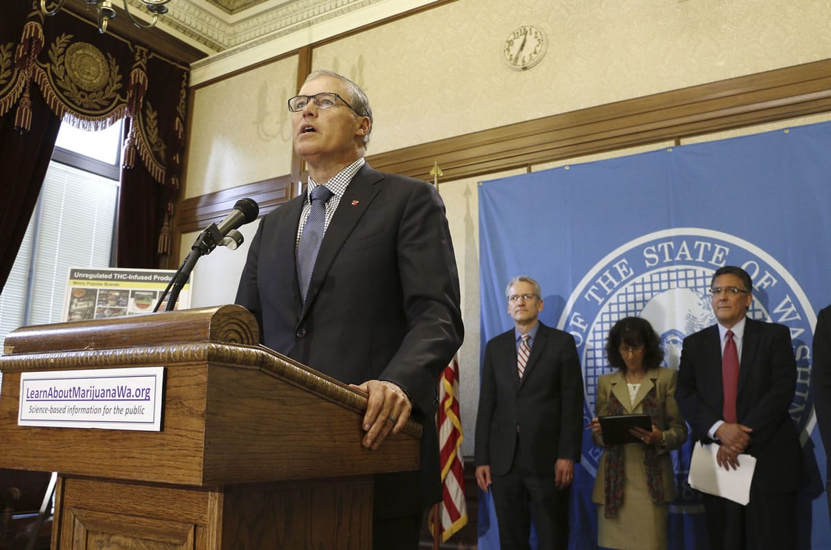 Gov. Jay Inslee, foreground, speaks to the media Tuesday in Olympia about public awareness and safety efforts the state is making in advance of the start of retail sales of recreational marijuana.