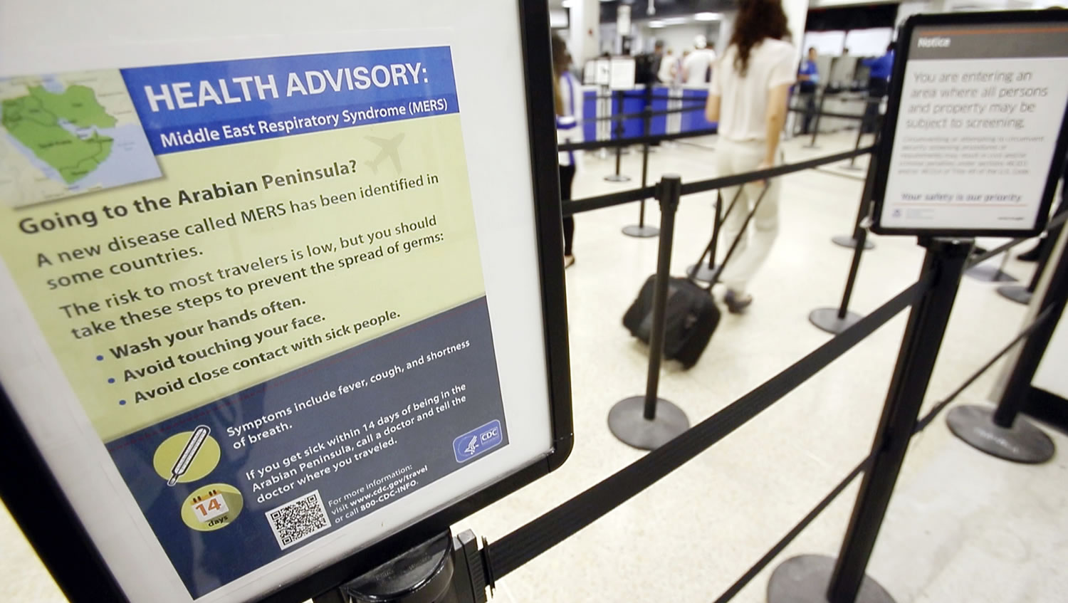A Center for Disease Control health advisory warning travelers about the risks of MERS, or Middle East Respiratory Syndrome, is shown at a TSA screening area, Wednesday at Miami International Airport in Miami.