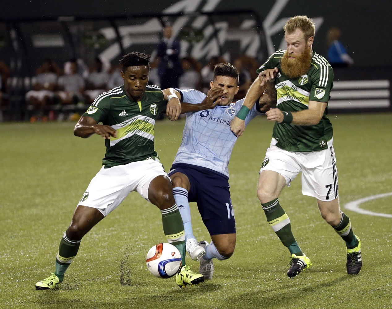 Sporting Kansas City forward Dom Dwyer, middle, battles for the ball with Portland Timbers midfielder George Fochive, left, and defender Nat Borchers during the first half of an MLS soccer match in Portland, Ore., Wednesday, Sept. 9, 2015.