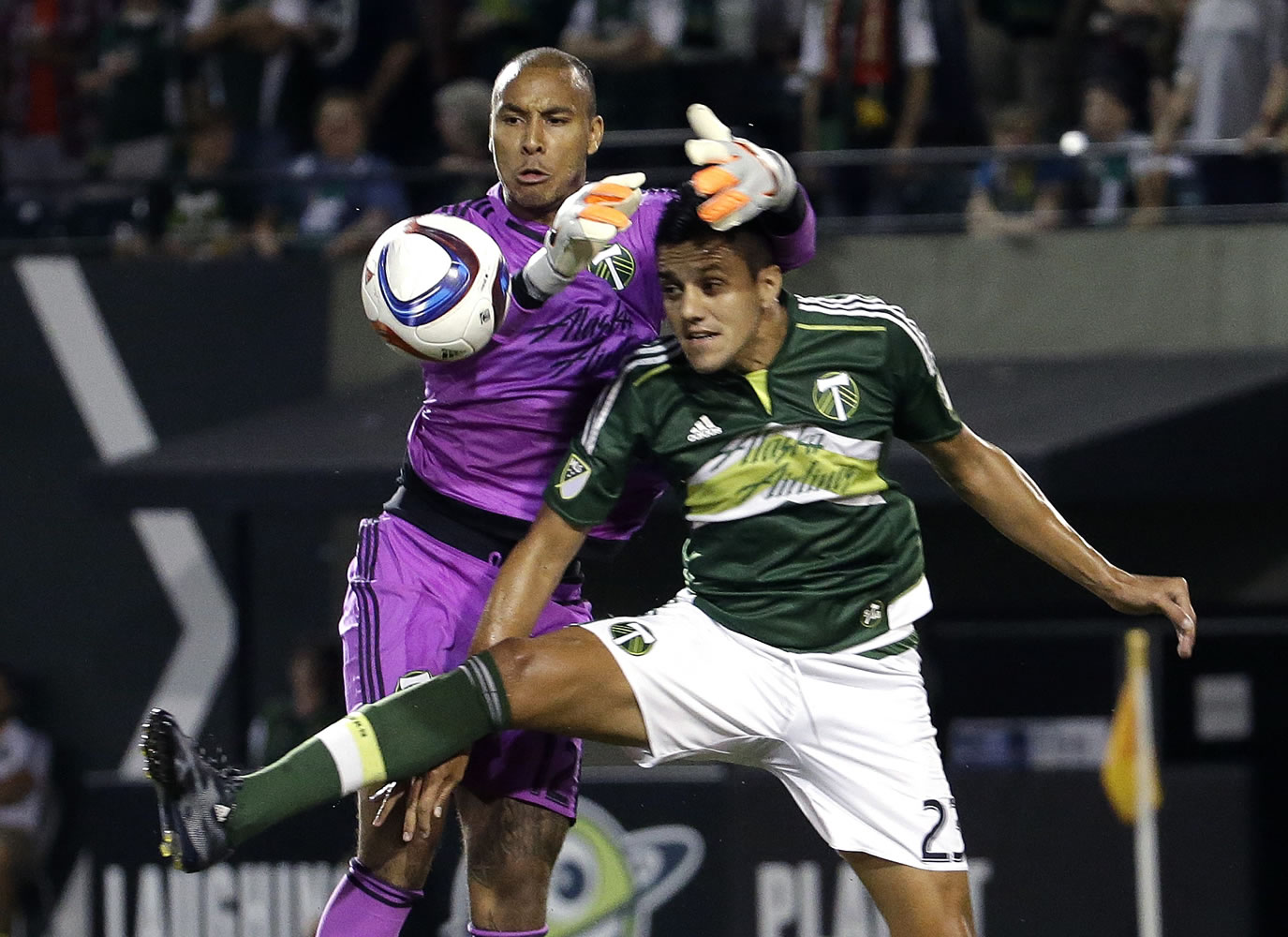 Portland Timbers goalkeeper Adam Kwarasey, left, goes over his defender Norberto Paparatto to grab a corner kick during the first half of an MLS soccer match against Sporting Kansas City in Portland, Ore., Wednesday, Sept. 9, 2015.