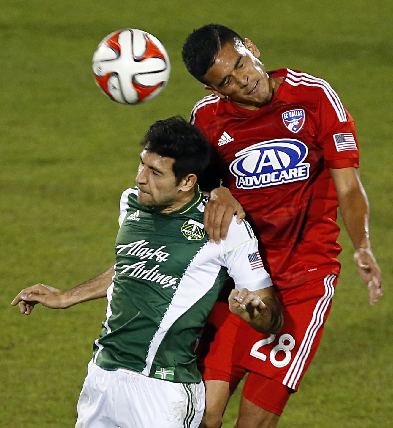 FC Dallas midfielder Victor Ulloa (28) and Portland Timbers midfielder Diego Valeri (8) go up for a header in the first half of an MLS soccer game at Toyota Stadium in Frisco, Texas, on Saturday, March 29, 2014.
