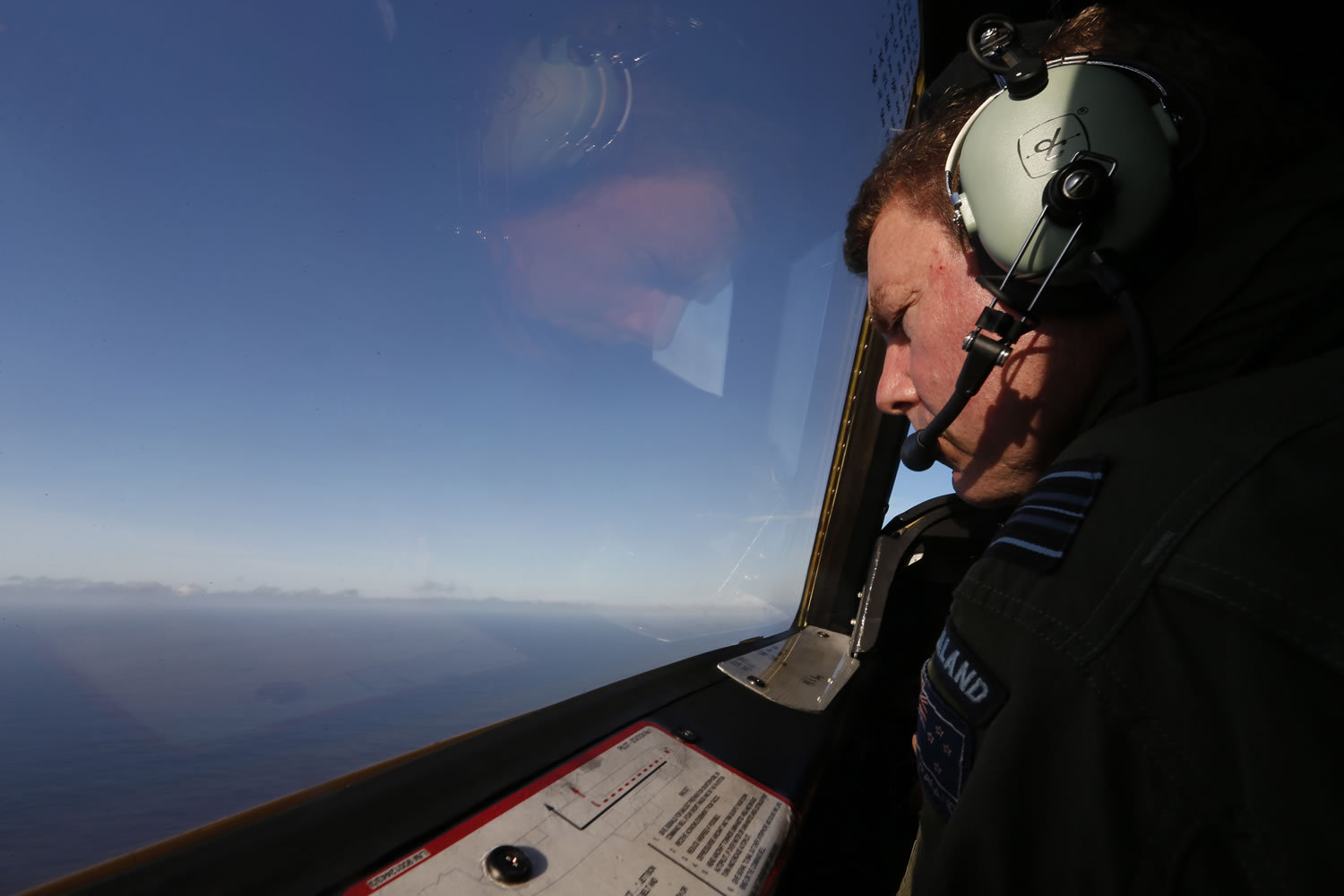 Royal New Zealand Air Force P-3K2 Orion co-pilot Brett McKenzie looks out from the cockpit for the missing jet Saturday over the Indian Ocean.
