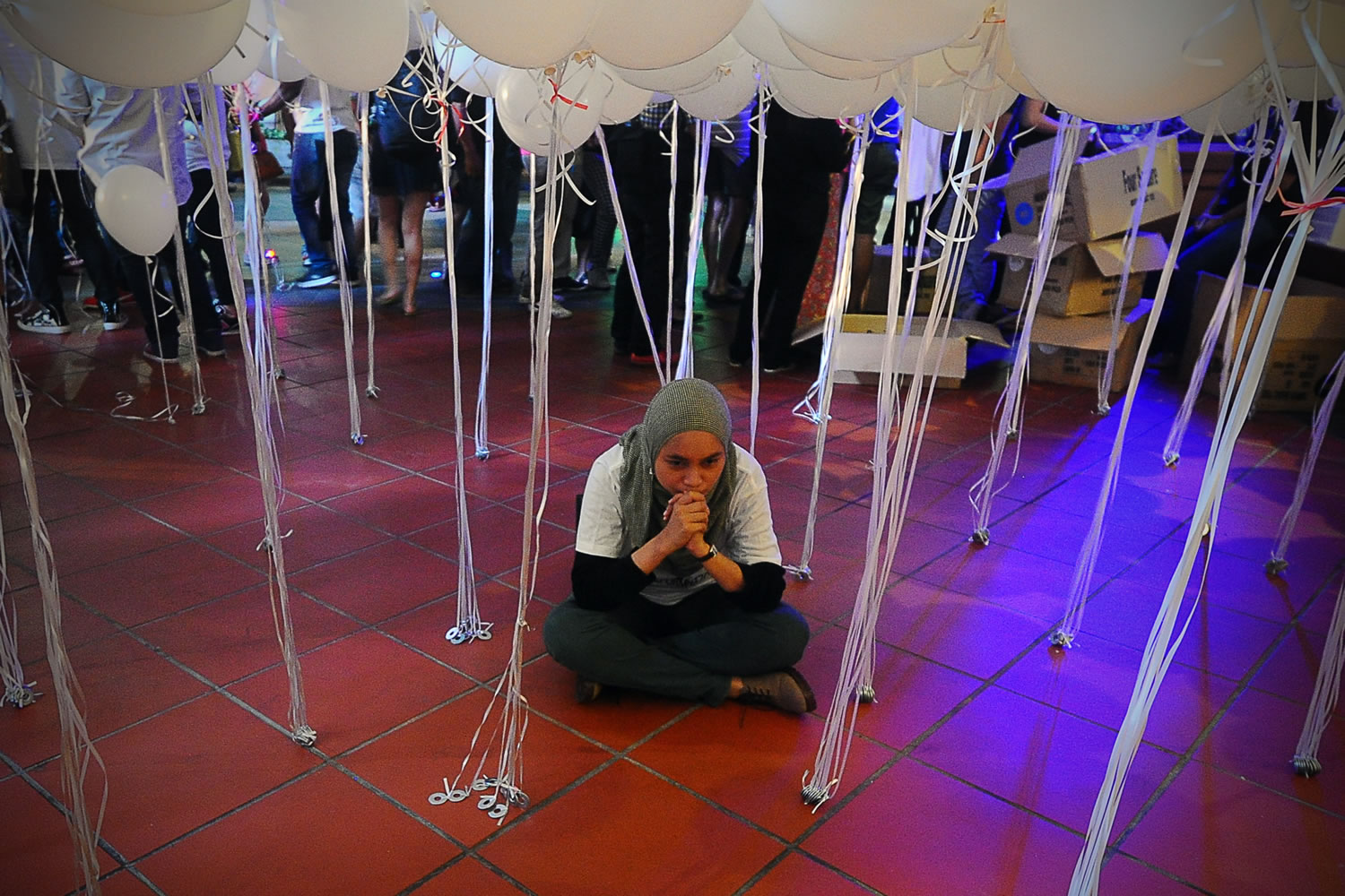 A Malaysian Muslim woman pauses during an event for the missing Malaysia Airline MH370 at a shopping mall in Petaling Jaya, on the outskirt of Kuala Lumpur, Malaysia, on Tuesday.