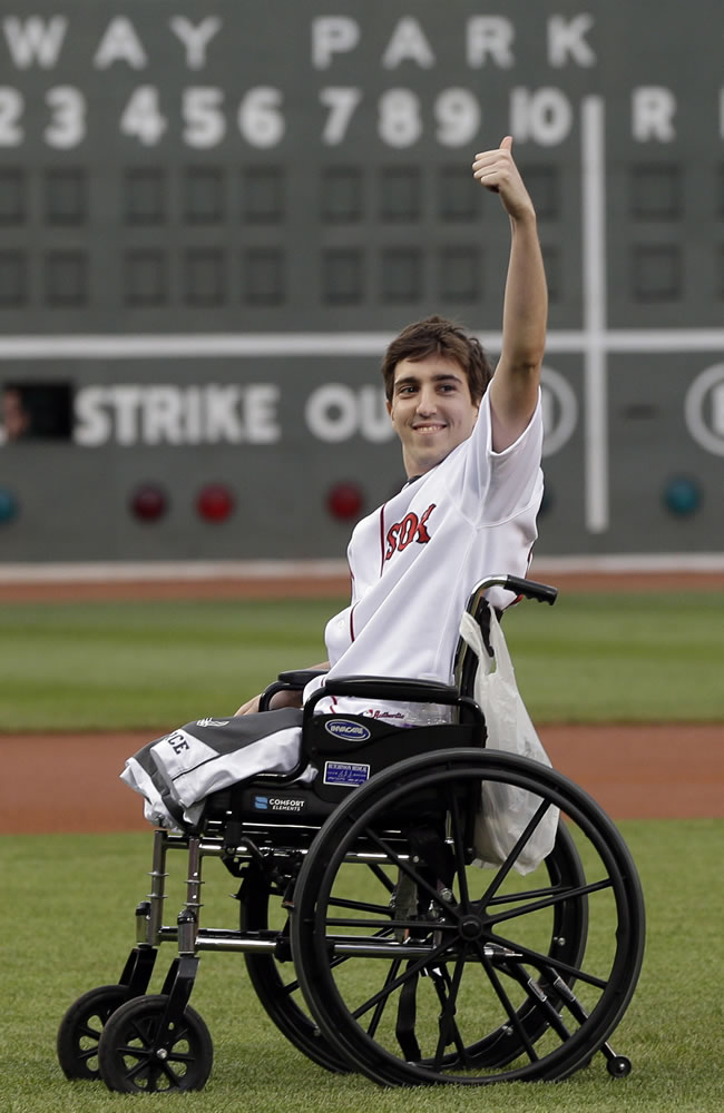 Associated Press files
Boston Marathon bombing survivor Jeff Bauman acknowledges cheering fans before throwing out a ceremonial first pitch at Fenway Park before a baseball game last year.
