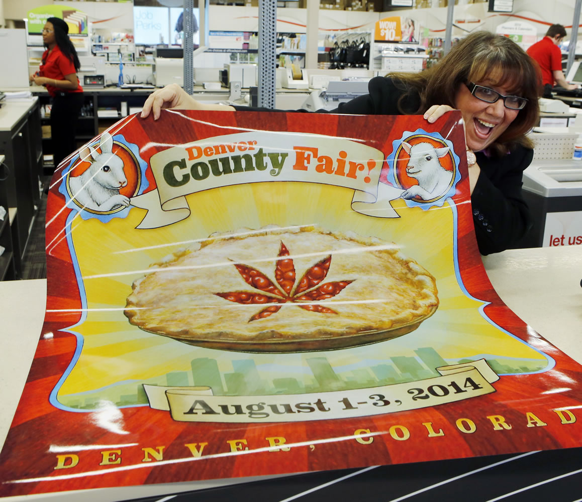 Dana Cain, director of the Denver County Fair, shows a poster advertising the fair at a print shop.