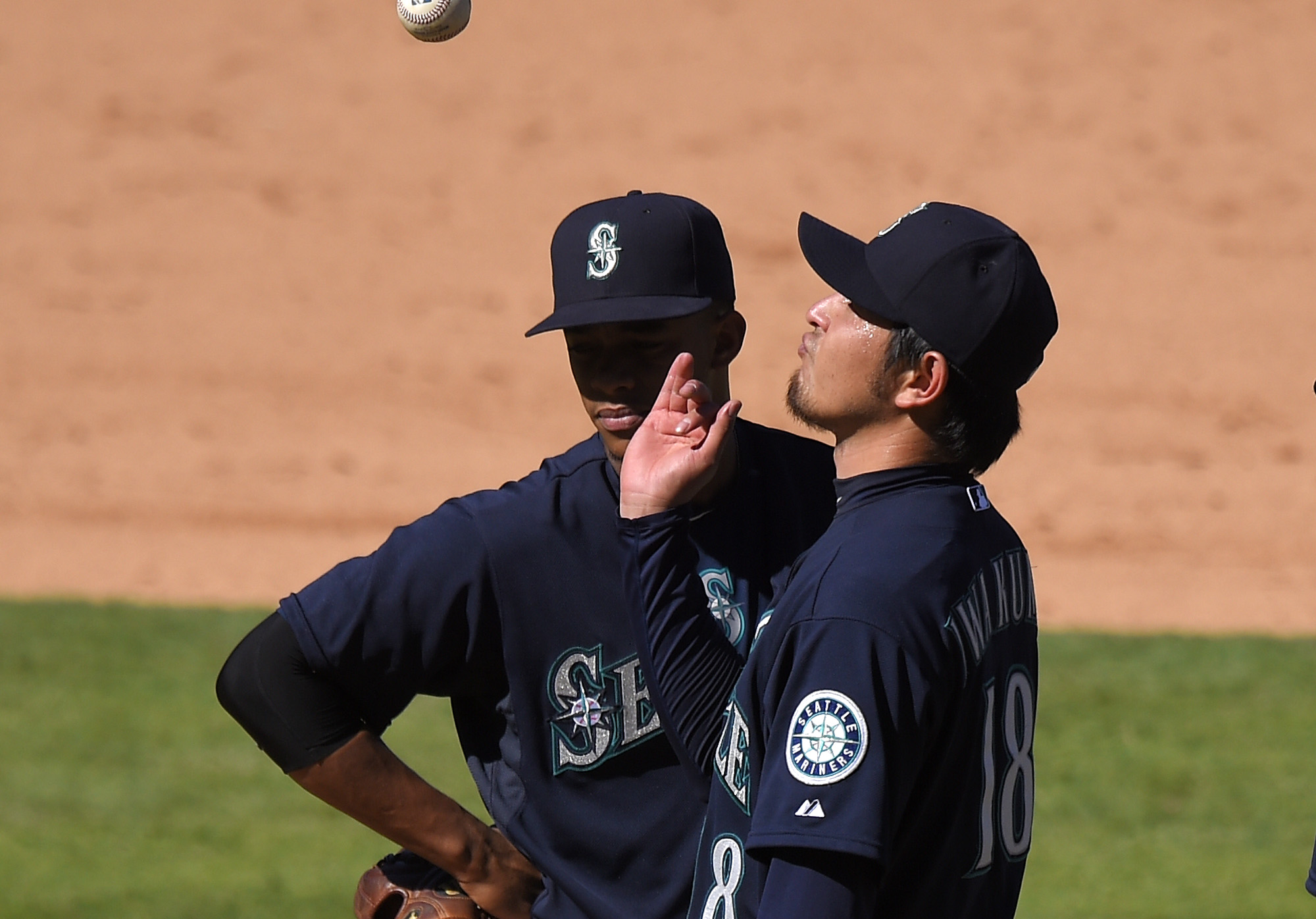 Seattle Mariners starting pitcher Hisashi Iwakuma tosses the ball in the air as he waits to be taken out of the game as shortstop Ketel Marte watches during the eighth inning against the Los Angeles Angels, Sunday, Sept. 27, 2015, in Anaheim, Calif. (AP Photo/Mark J.