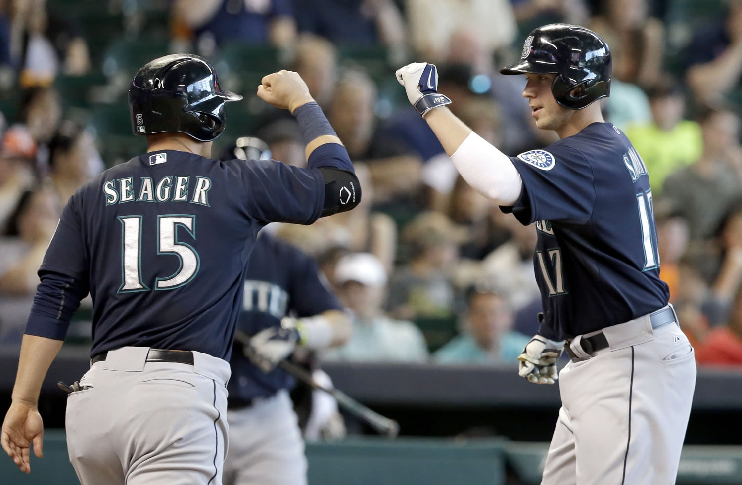 Seattle Mariners' Justin Smoak (17) is welcomed home by teammate Kyle Seager (15) on a two-run home run against the Houston Astros in the seventh inning of a baseball game on Saturday, May 3, 2014, in Houston.
