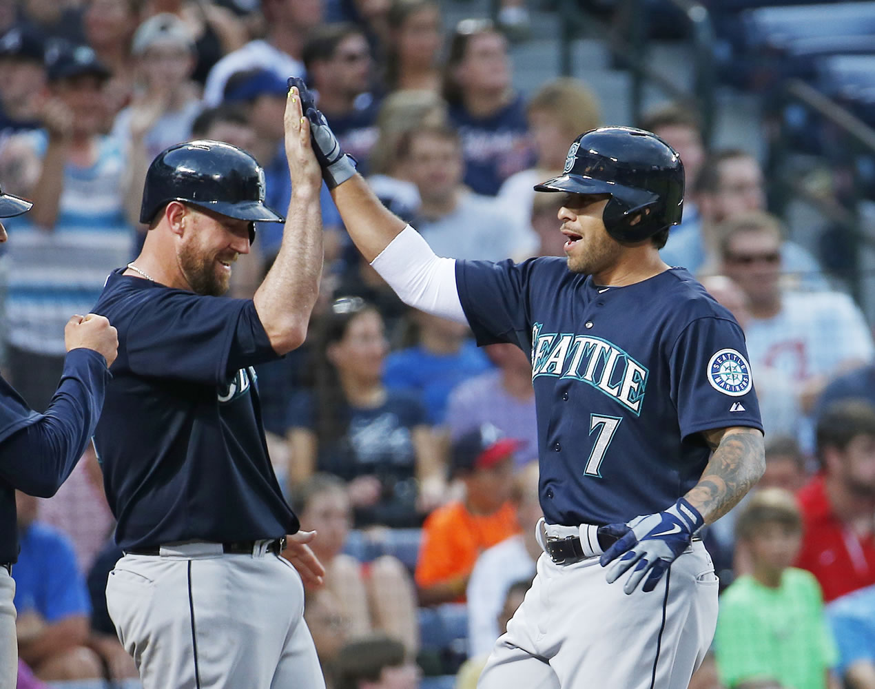 Seattle Mariners pinch-hitter Stefen Romero (7) celebrates his three-run homer with John Buck in the fourth inning of a baseball game against the Atlanta Braves on Tuesday in Atlanta.