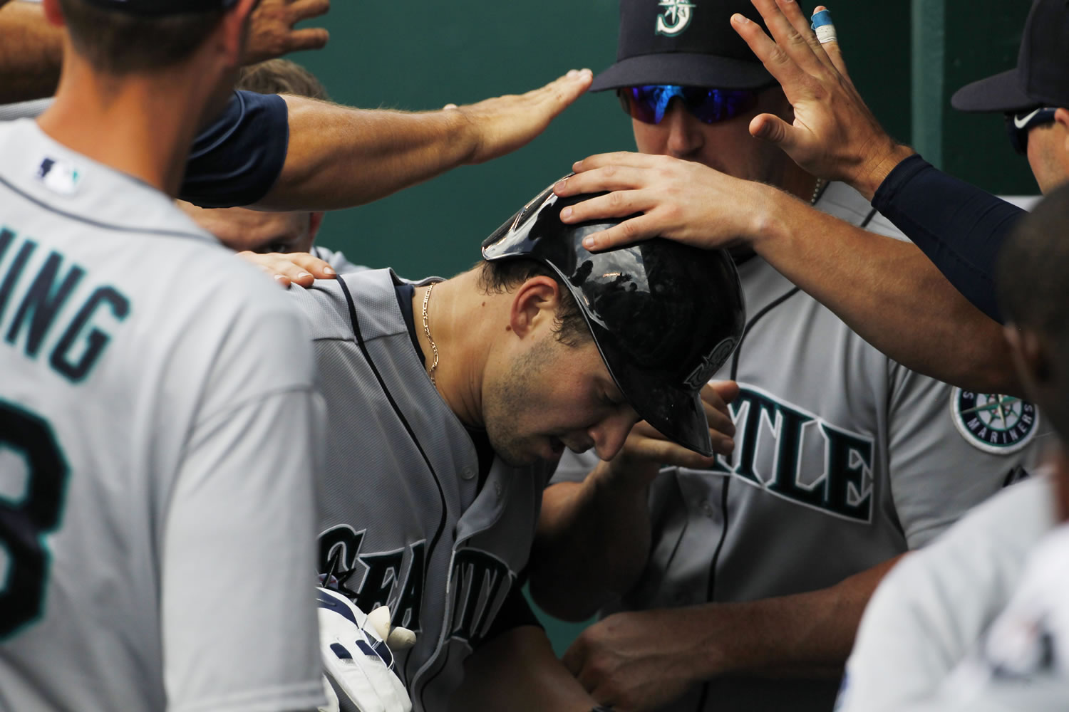Seattle Mariners' Mike Zunino, center, is congratulated by his teammates in the dugout after hitting a home run against the Kansas City Royals in the seventh inning of a baseball game at Kauffman Stadium in Kansas City, Mo., Sunday, June 22, 2014. (AP Photo/Colin E.