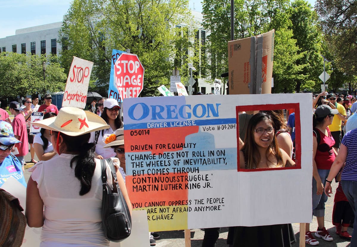 Nathalie Marquez holds a sign modeled after an Oregon driver's license at the Capitol on Thursday in Salem, Ore.