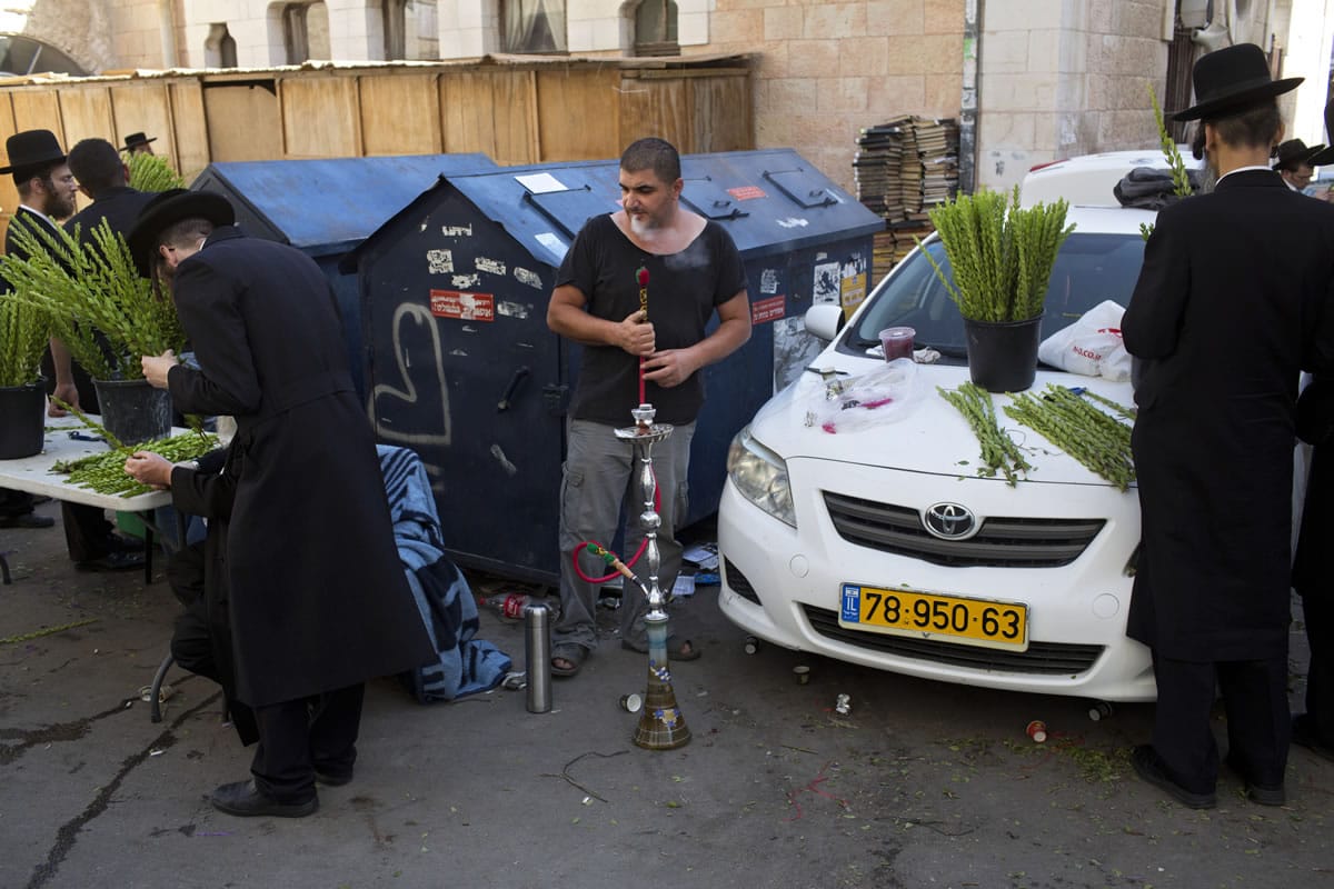 An Israeli Arab man sells myrtle branches to Ultra-Orthodox Jews to be used as a symbol on the Jewish holiday of Sukkot in Jerusalem on Thursday. The holiday commemorates the Israelites 40 years of wandering in the desert and a decorated hut is erected outside religious households as a sign of temporary shelter. The weeklong holiday begins on Sunday.