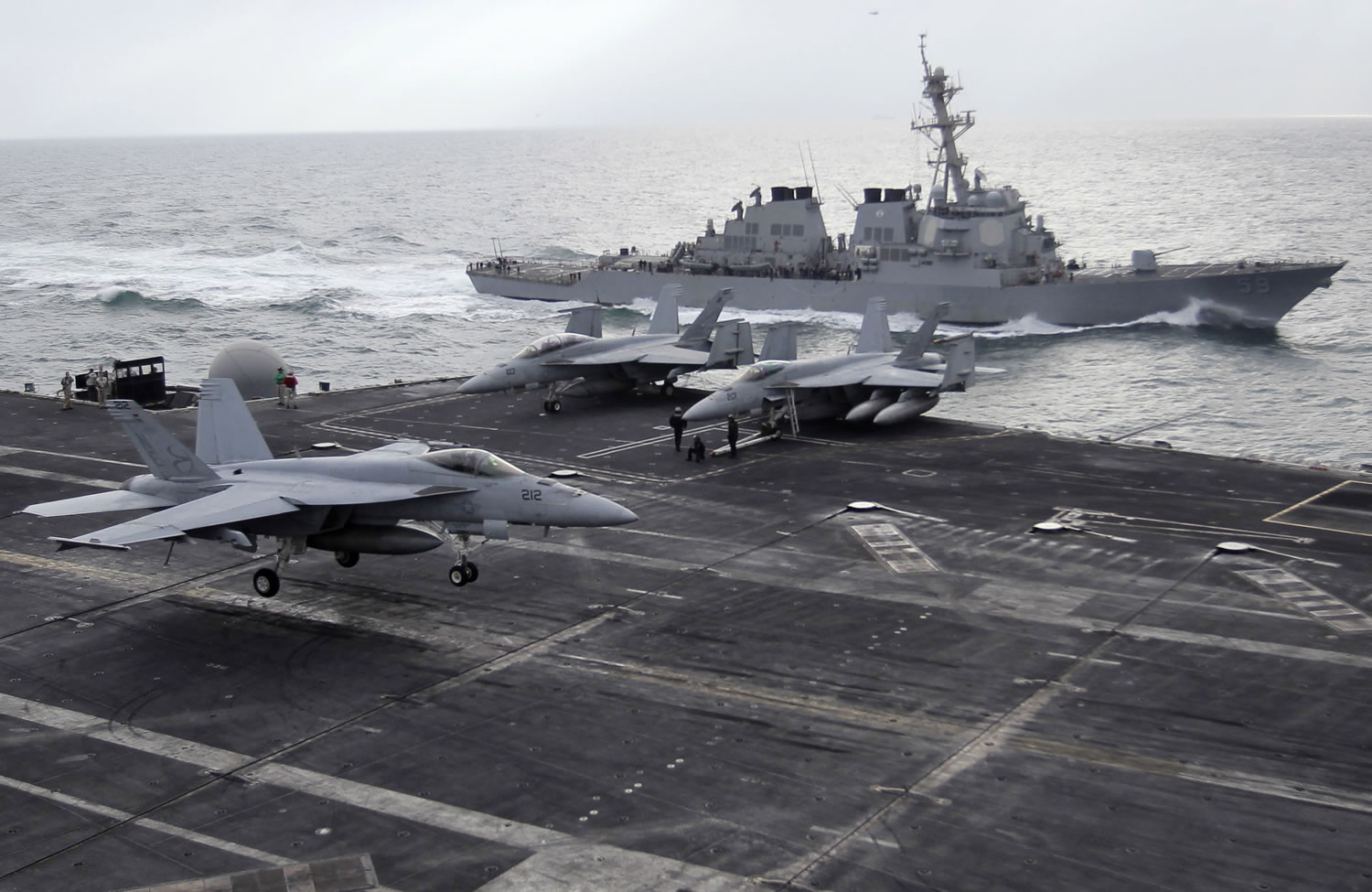 Associated Press files
A U.S. F-18 fighter jet, left, lands Feb. 13, 2012, on the Nimitz-class aircraft carrier USS Abraham Lincoln as a U.S. destroyer sails alongside during fly exercises in the Persian Gulf. Iran's naval chief said Tuesday the nation is building a large-scale mock-up of a U.S. carrier for target practice.
