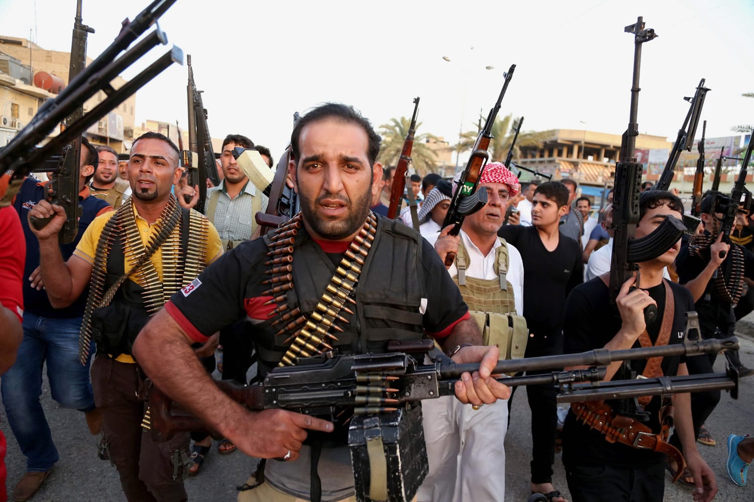 Iraqi Shiite tribal fighters deploy with their weapons while chanting slogans against the al-Qaida-inspired Islamic State of Iraq and the Levant (ISIL),  to help the military, which defends the capital in Baghdad's Sadr City, Iraq, Friday, June 13, 2014.