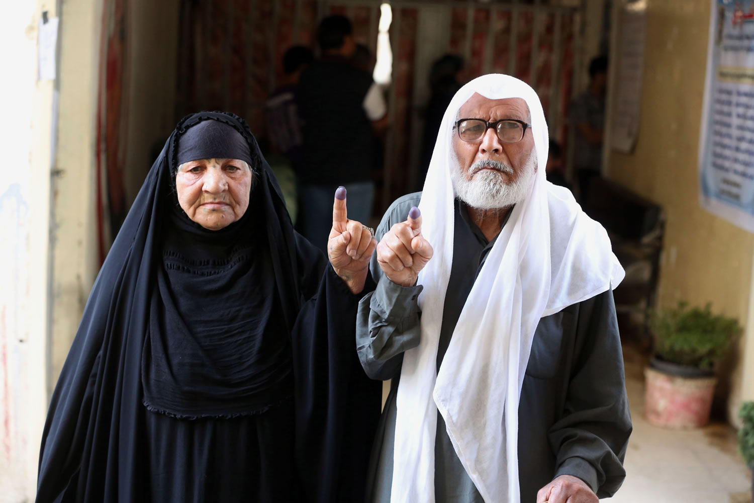 A man and his wife show their inked fingers after casting their votes Wednesday at a polling station in Baghdad, Iraq.