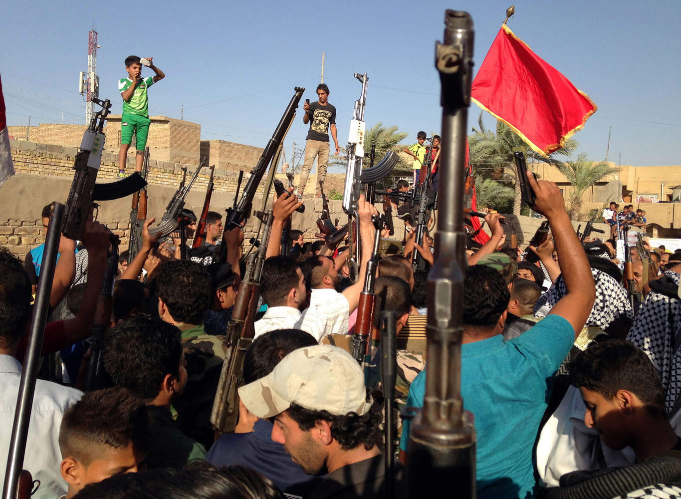 Shiite tribal fighters raise their weapons and chant slogans against the al-Qaida-inspired Islamic State of Iraq and the Levant on Sunday in the east Baghdad neighborhood of Kamaliya, Iraq.