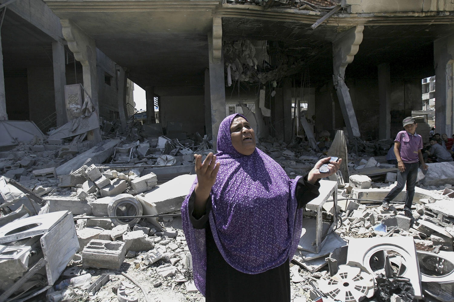 A Palestinian woman gets emotional as she stands on the rubble of a house belong to al Akhras family after it was hit by an Israeli strike in Rafah refugee camp, in the southern Gaza Strip, early Tuesday .