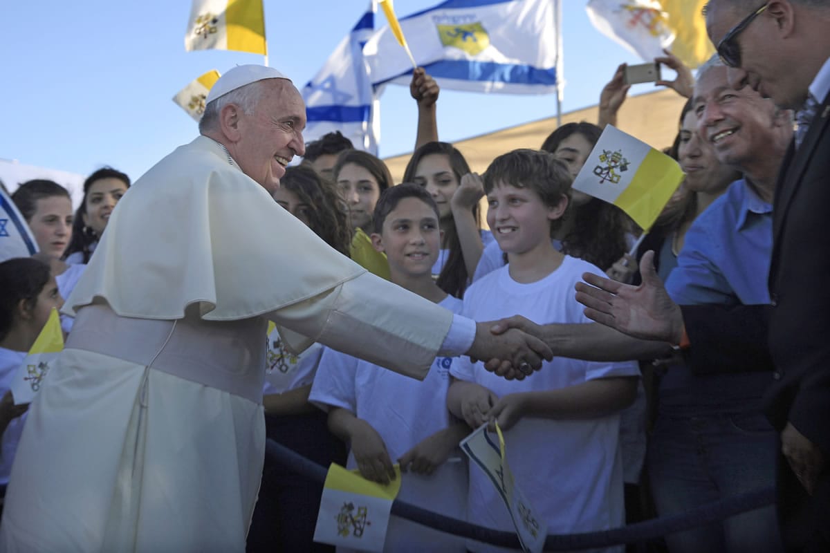 Pope Francis greets Israeli children Sunday after at the heliport of Hadassah hospital in mount Scopus Jerusalem. Pope Francis took a dramatic plunge Sunday into Mideast politics while on his Holy Land pilgrimage, receiving an acceptance from the Israeli and Palestinian presidents to visit him at the Vatican next month to discuss embattled peace efforts.