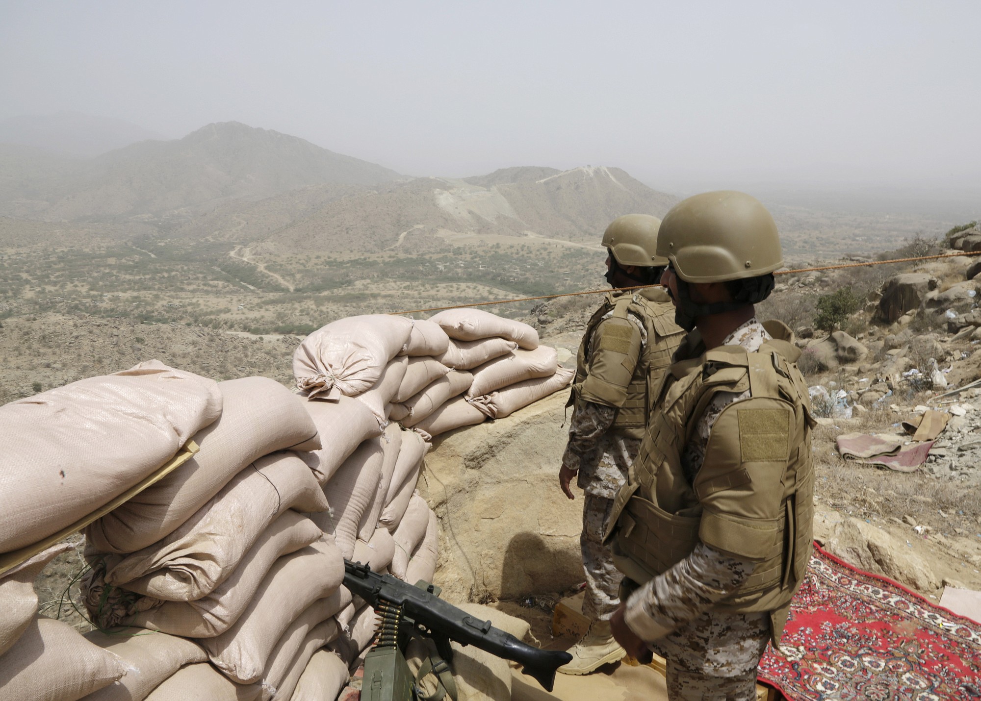 Saudi soldiers stand guard  from behind a sandbag barricade at the border with Yemen in Jazan, Saudi Arabia, on Monday.