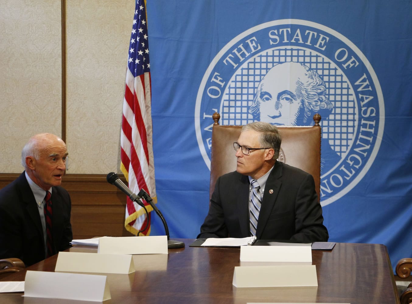 Gov. Jay Inslee, right, listens to Rich Hadley, president emeritus of Greater Spokane Inc., before signing an agreement for a renewed Washington Military Alliance in Olympia on Wednesday.