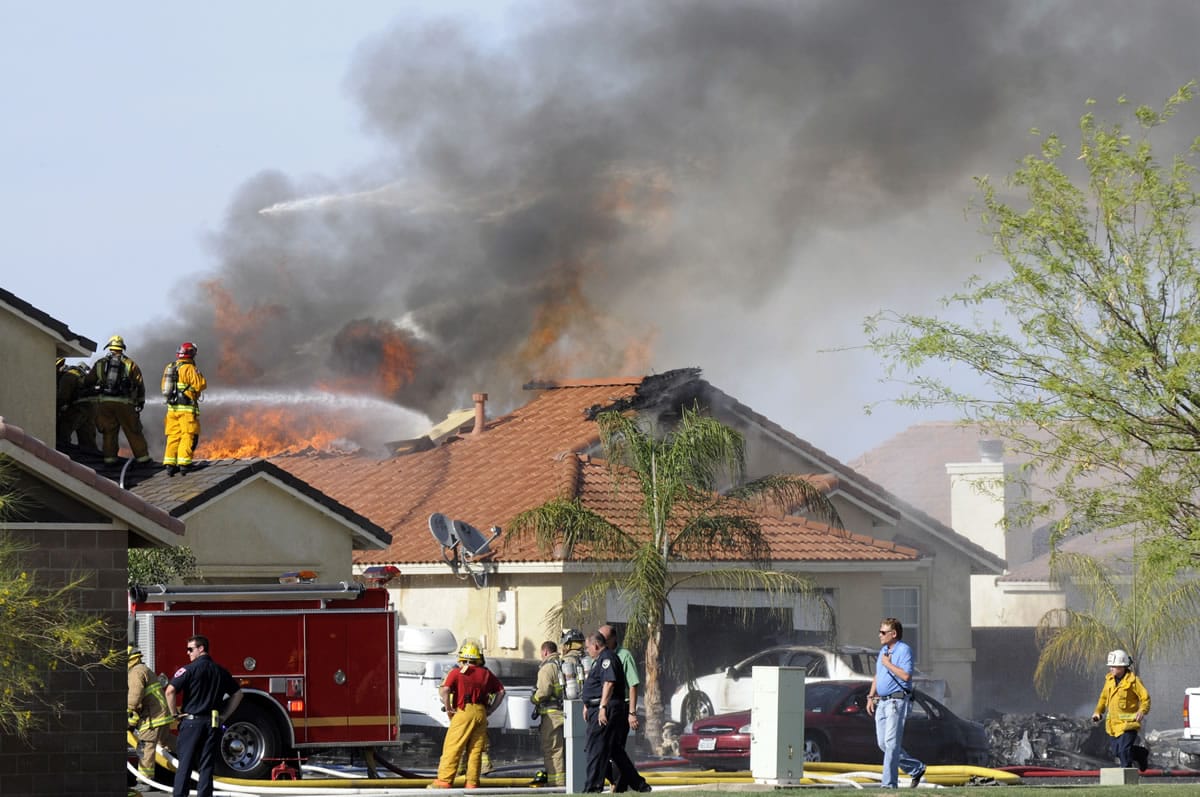 Firefighters work to douse flames Wednesday on a street in Imperial, Calif., where a military jet crashed setting two homes on fire. A U.S.