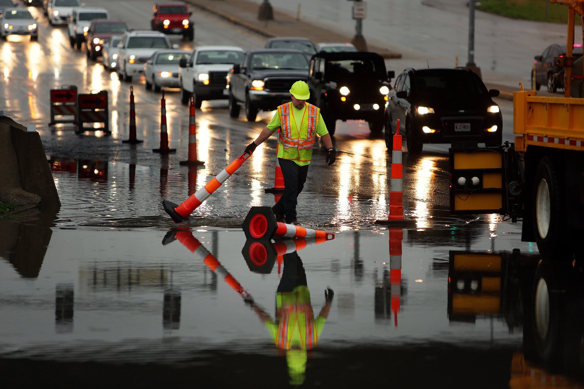 A Missouri Department of Transportation worker adjusts cones on a flooded section of south bound Route 141 underneath Interstate 44 after a storm flooded the area on Tuesday near Valley Park, Mo.