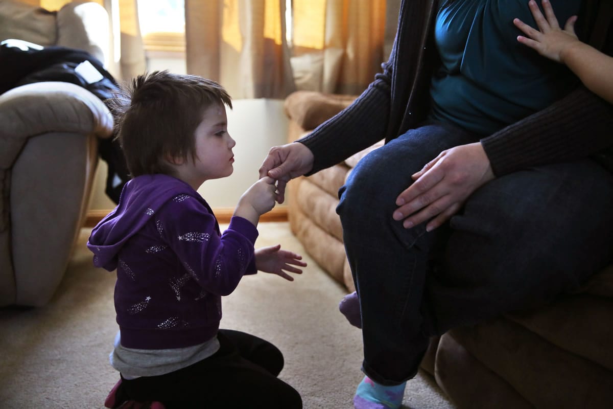 In this Feb. 7, 2014 photo, Elizabeth Burger, 4, holds her mother's hand at home in Colorado Springs, Colo. Elizabeth suffers from severe epilepsy and is receiving experimental treatment with a special strain of medical marijuana, which she takes orally as drops of oil. After years of nearly losing their daughter while trying and failing with dozens of mainstream treatments, Elizabeth's parents moved from the east coast to Colorado, where they say they have had luck with Charlotte's Web, a proprietary strain of medical marijuana in which the psychoactive THC has been largely bred out, and the other cannabinoid compounds thought to be medically useful accentuated.