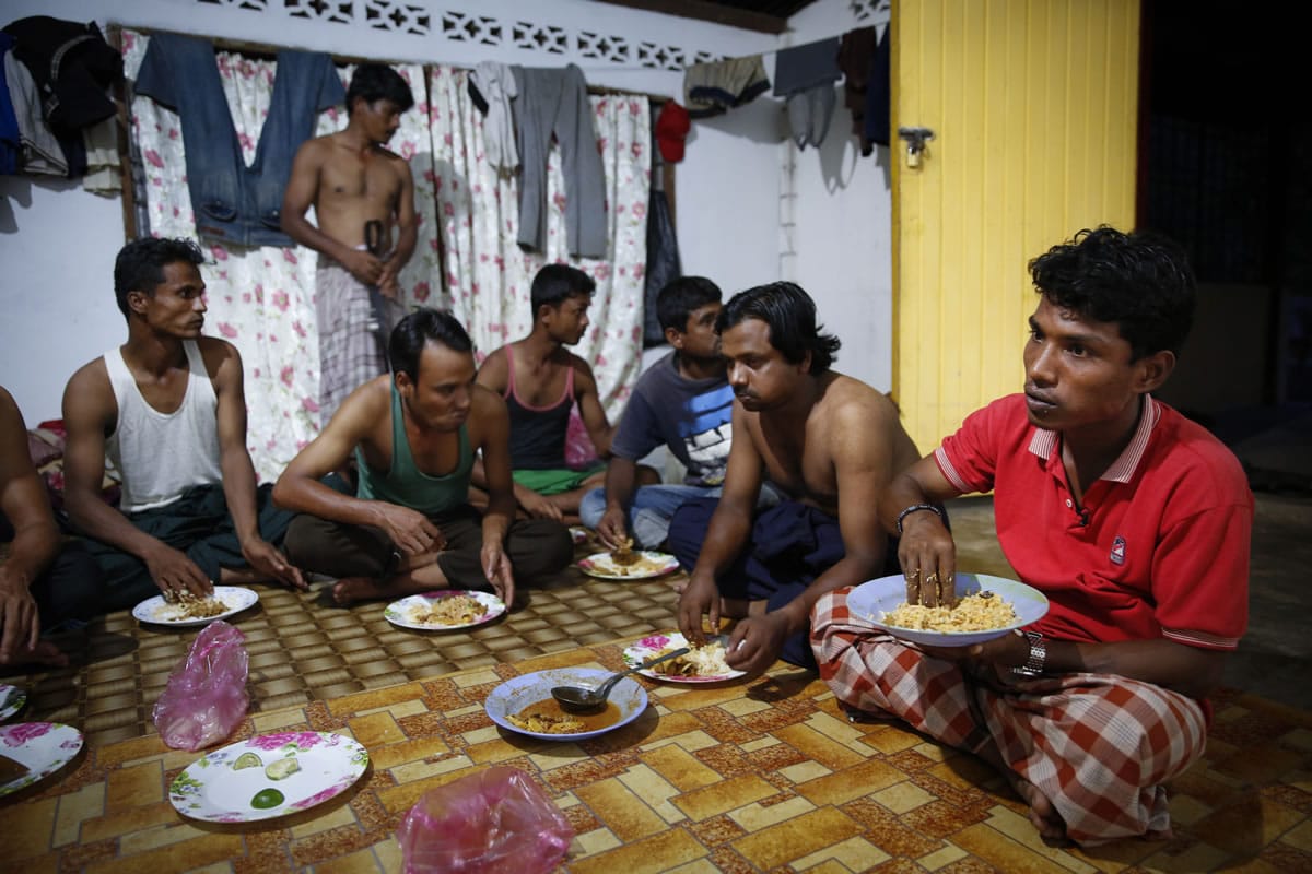 In this Nov. 23, 2013 photo, Rohingya refugee Mohamad Husein, right, from Myanmar, eats dinner at his hostel with his compatriots on the outskirts of Alor Setar, Kedah, North Malaysia. For many fleeing Rohingya, Malaysia, is the preferred destination. Around 33,000 are registered there and an equal number are undocumented, according to the Rohingya Society of Malaysia. Those numbers have swelled with the violence in Myanmar.