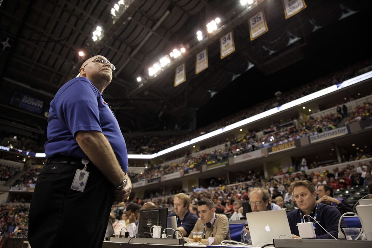 Bill Hefler of ESG Security looks up to the stands during a timeout in the second half of an NCAA college basketball game between Ohio State and Michigan in the semifinals of the Big Ten Conference tournament in Indianapolis earlier this month.
