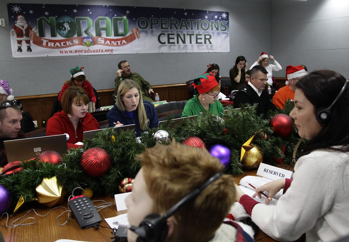 Associated Press files
Volunteers take phone calls from children asking where Santa is during the annual NORAD Tracks Santa Operation on Christmas Eve 2012 at the North American Aerospace Defense Command at Peterson Air Force Base in Colorado Springs, Colo.