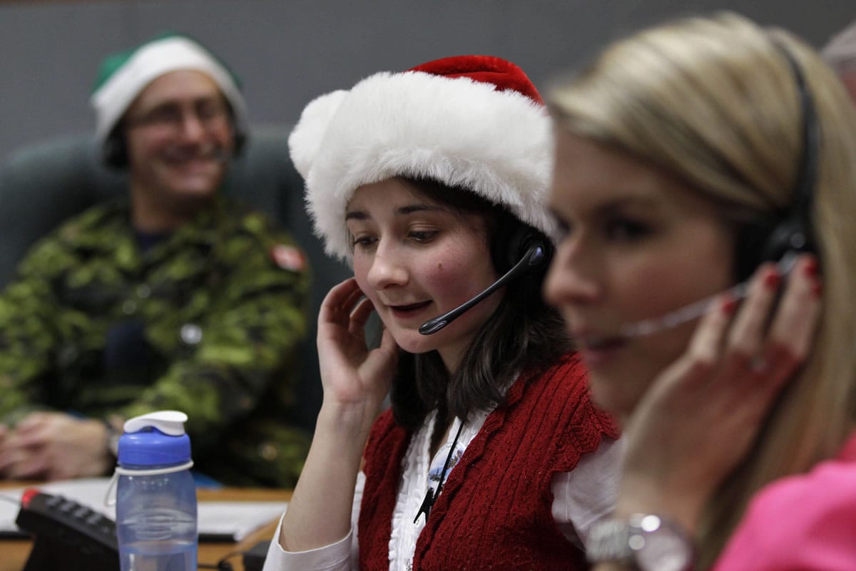Volunteer Katherine Beaupre takes phone calls from children asking where Santa is and when he will deliver presents to their house, during the annual NORAD Tracks Santa Operation, at the North American Aerospace Defense Command, or NORAD, at Peterson Air Force Base, Colo., in 2012.