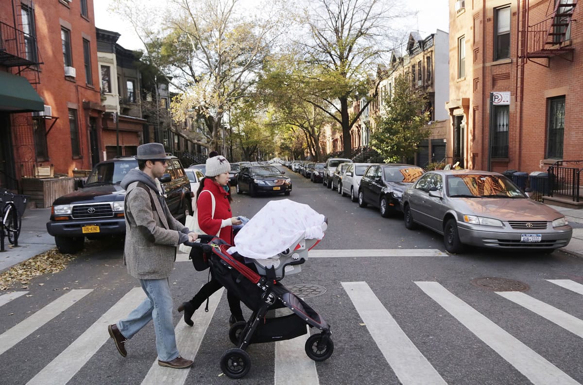 Associated Press files
A couple with a baby stroller cross the street in the Park Slope neighborhood in the Brooklyn borough of New York. More people are naming their children Brooklyn.