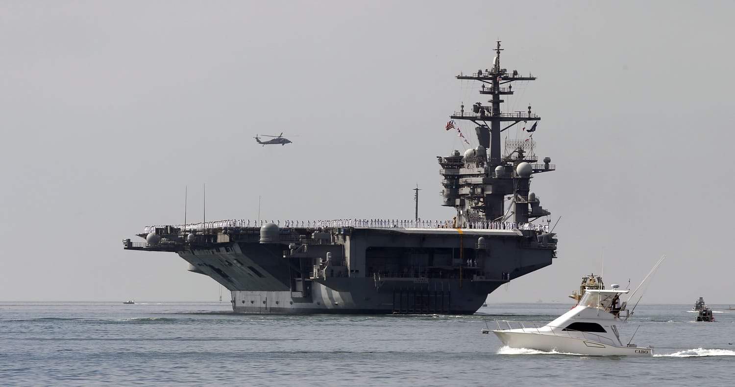 The aircraft carrier USS Carl Vinson sails out of San Diego Harbor on Aug. 22, leaving for a nine-month deployment in San Diego. Two U.S. Navy jets crashed into the western Pacific Ocean, where one pilot was rescued and another was missing. A search for the missing pilot was underway.