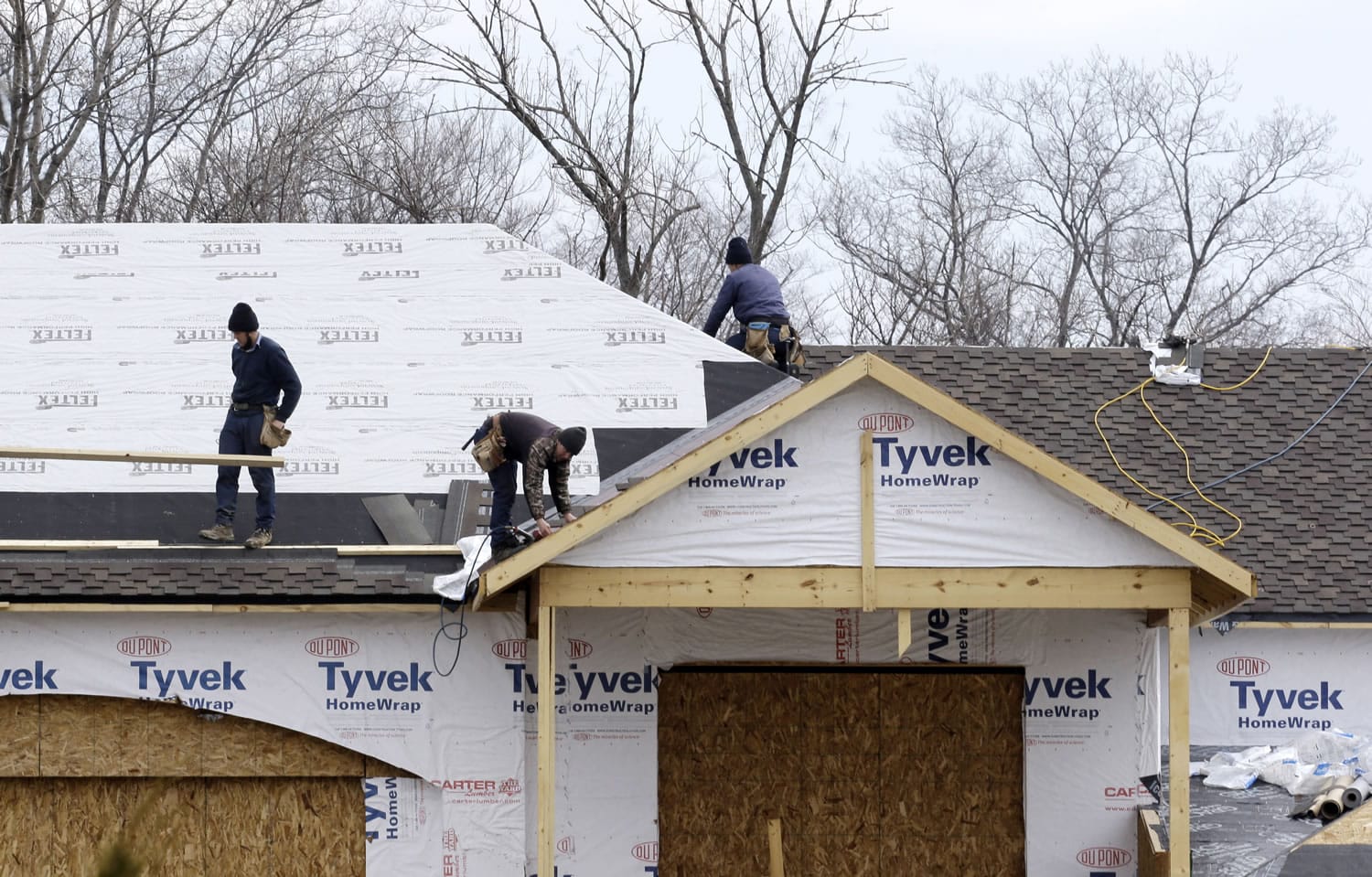 Roofers install a roof on a new construction home in Pepper Pike, Ohio.