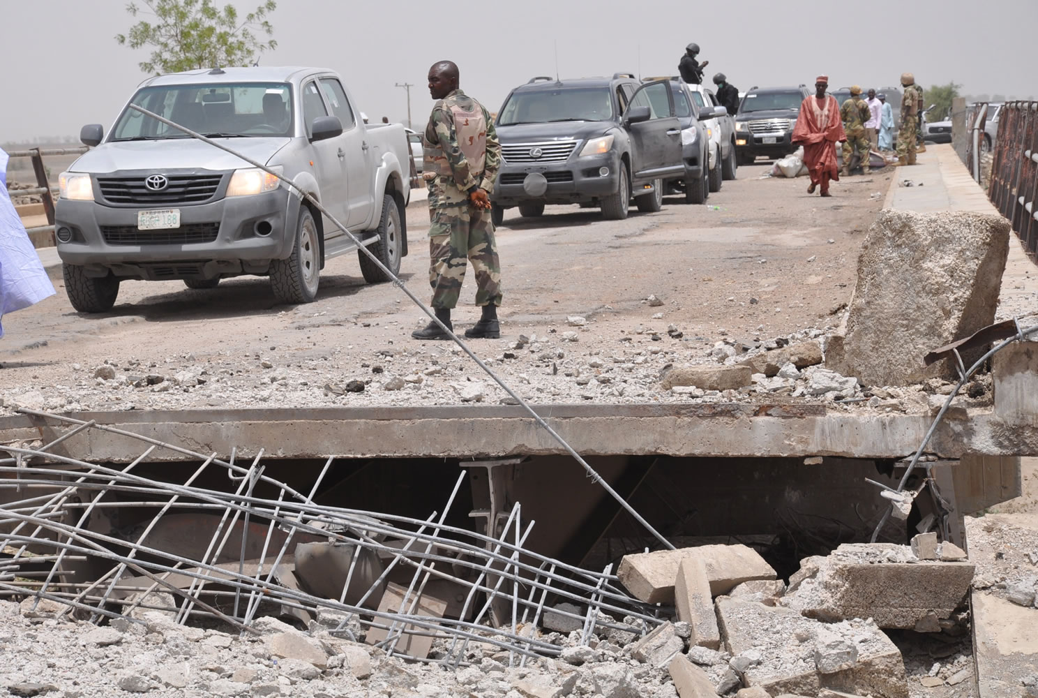 A soldier and government officials inspects the bridge that link Nigeria and Cameroon following an attacked May 11 by Islamic militants in Gambaru, Nigeria.
