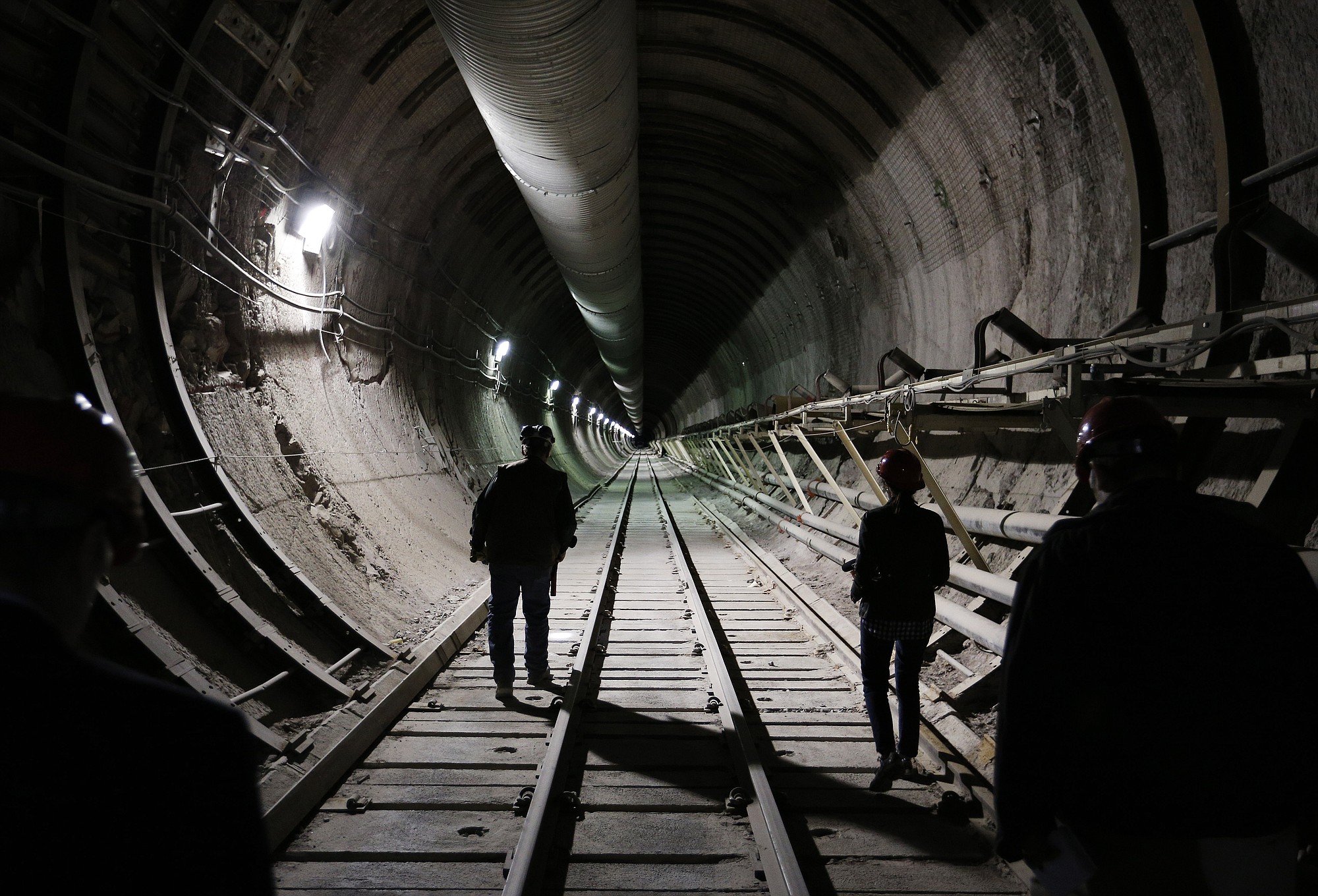 People walk in a tunnel through Yucca Mountain during a congressional tour Thursday near Mercury, Nev.