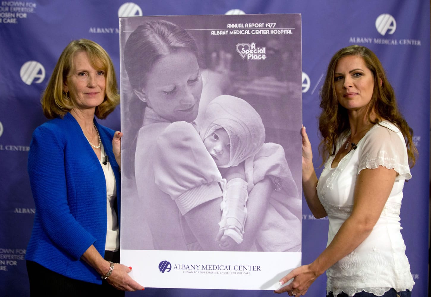 Nurse Susan Berger, left, and Amanda Scarpinati hold a copy of a 1977 Albany Medical Center annual report during a news conference at Albany Medical Center in Albany, N.Y., on Tuesday. Scarpinati, who suffered severe burns as an infant, is finally getting the chance to thank Berger, who cared for her, thanks to 38-year-old photos.