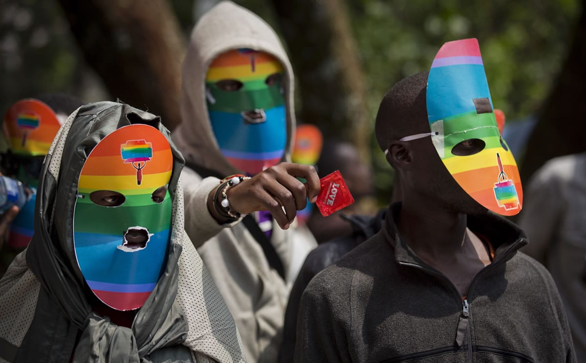 Kenyan gays and lesbians and others supporting their cause wear masks to preserve their anonymity, and one holds out a wrapped condom, as they stage a rare protest last Monday against Uganda's increasingly tough stance against homosexuality.