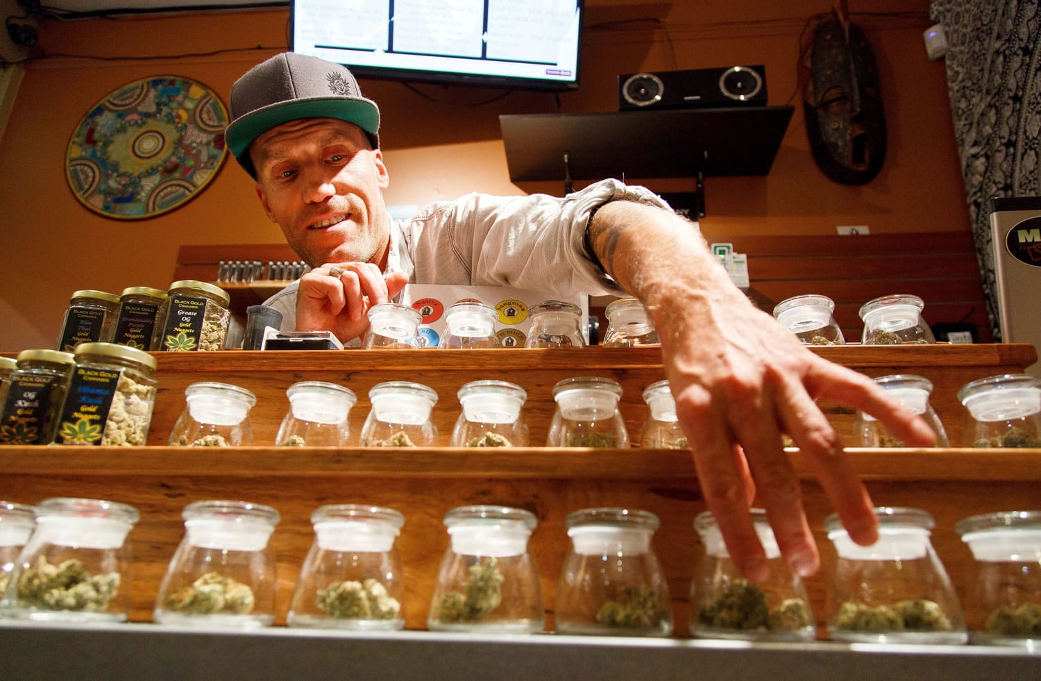 Shane Cavanaugh, owner of Amazon Organics, a pot dispensary in Eugene, Ore., arranges the cannabis display Monday in his store. Medical marijuana dispensaries in Oregon will be able to sell recreational marijuana starting today.