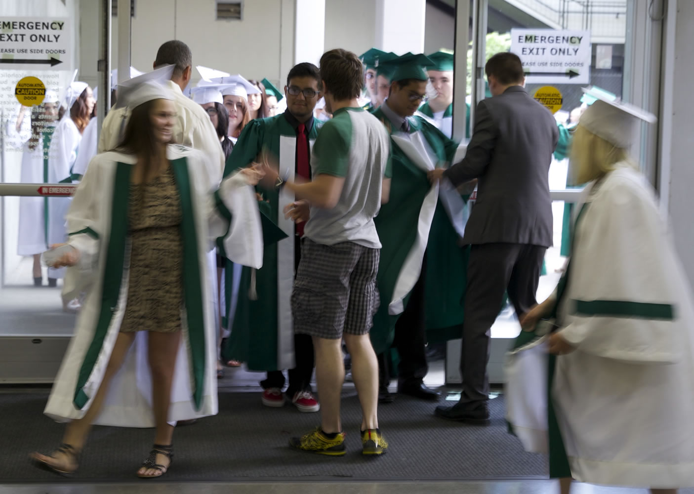 Students open their gowns as they enter the building Thursday for the Reynolds High School graduation ceremony at Veterans Memorial Coliseum in Portland.