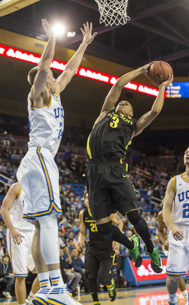 Oregon guard Joseph Young, right, goes up for a lay up against UCLA forward Travis Wear in the first half Thursday. (AP Photo/Ringo H.W.
