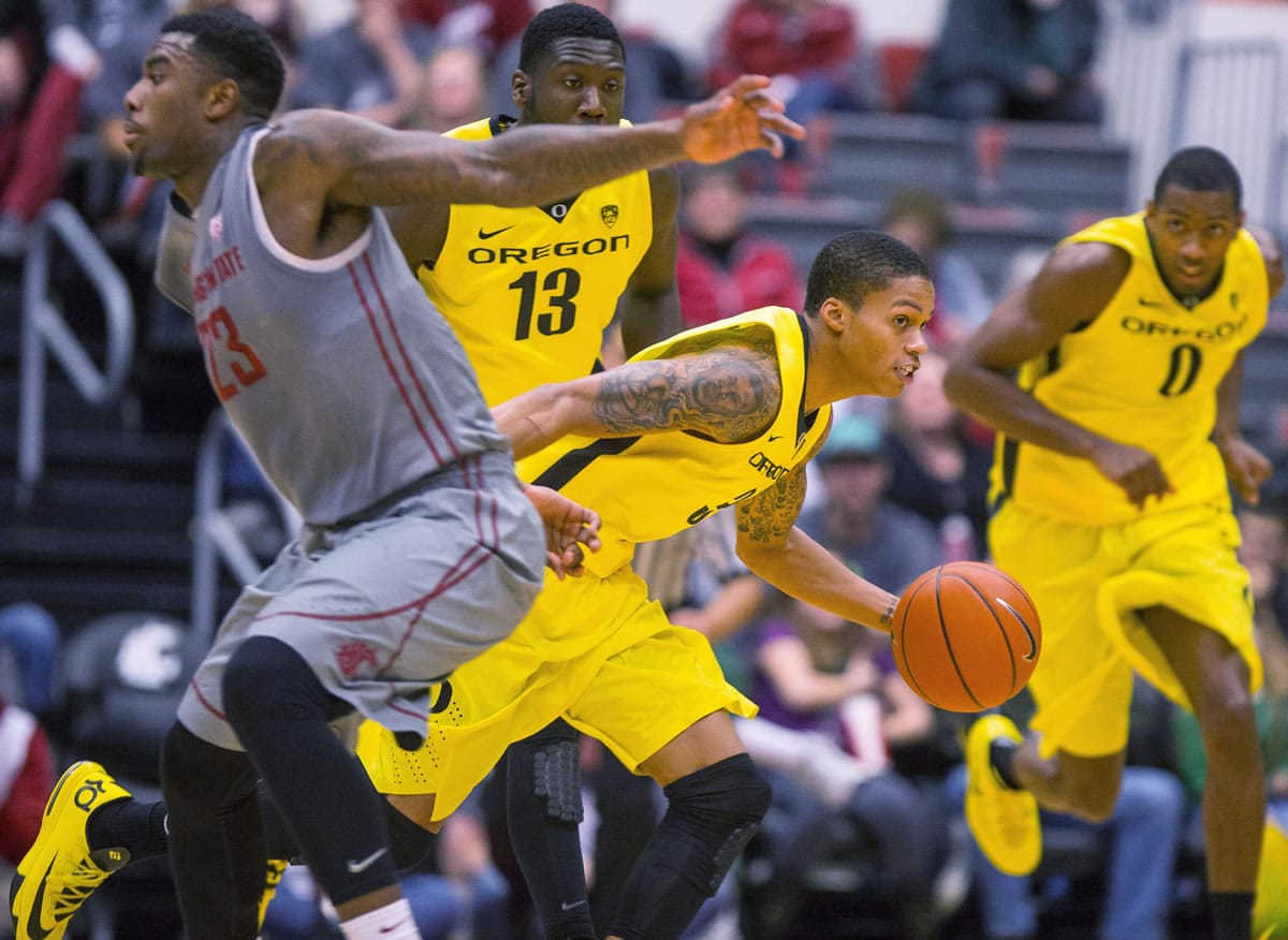 Oregon guard Joseph Young (3) pushes the ball up-court around Washington State forward D.J. Shelton (23) after grabbing a rebound Sunday in Pullman.