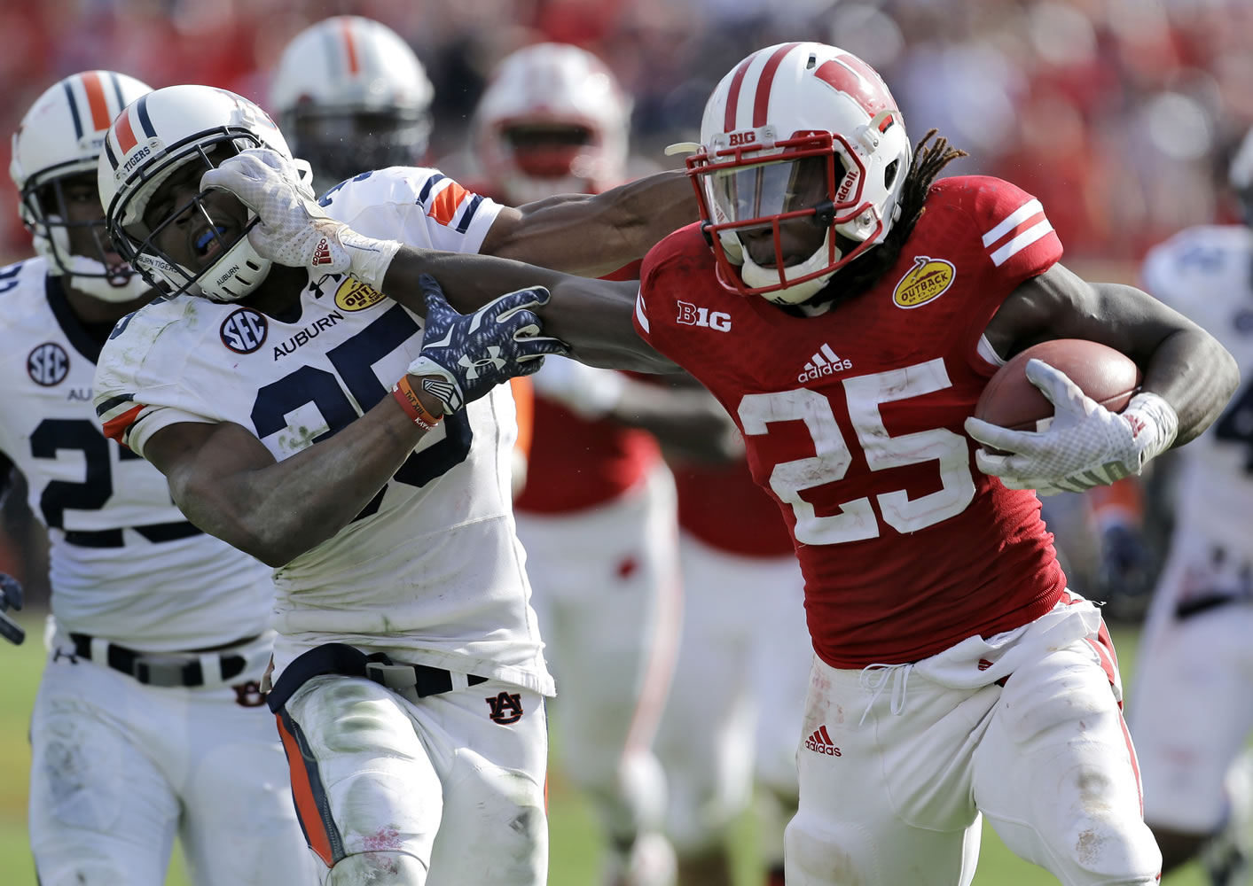 Wisconsin running back Melvin Gordon (25) stiff arms Auburn defensive back Jermaine Whitehead (35) on a 53-yard touchdown run during the third quarter of the Outback Bowl on Thursday.