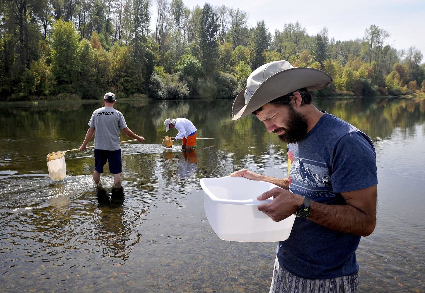 ADVANCE FOR WEEKEND EDITIONS, SEPT. 5-6 - In this photo taken Thursday, Aug. 27, 2015, Nathan Harris, a fourth grade teacher at Adams Elementary School, looks at macroinvertebrates at Tripp Island along the Willamette River near Corvallis, Ore. Harris was one of the teachers participating in an education program coordinated by the Institute of Applied Ecology.
